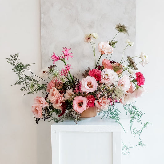 Table arrangement of luxurious pink toned flowers.
