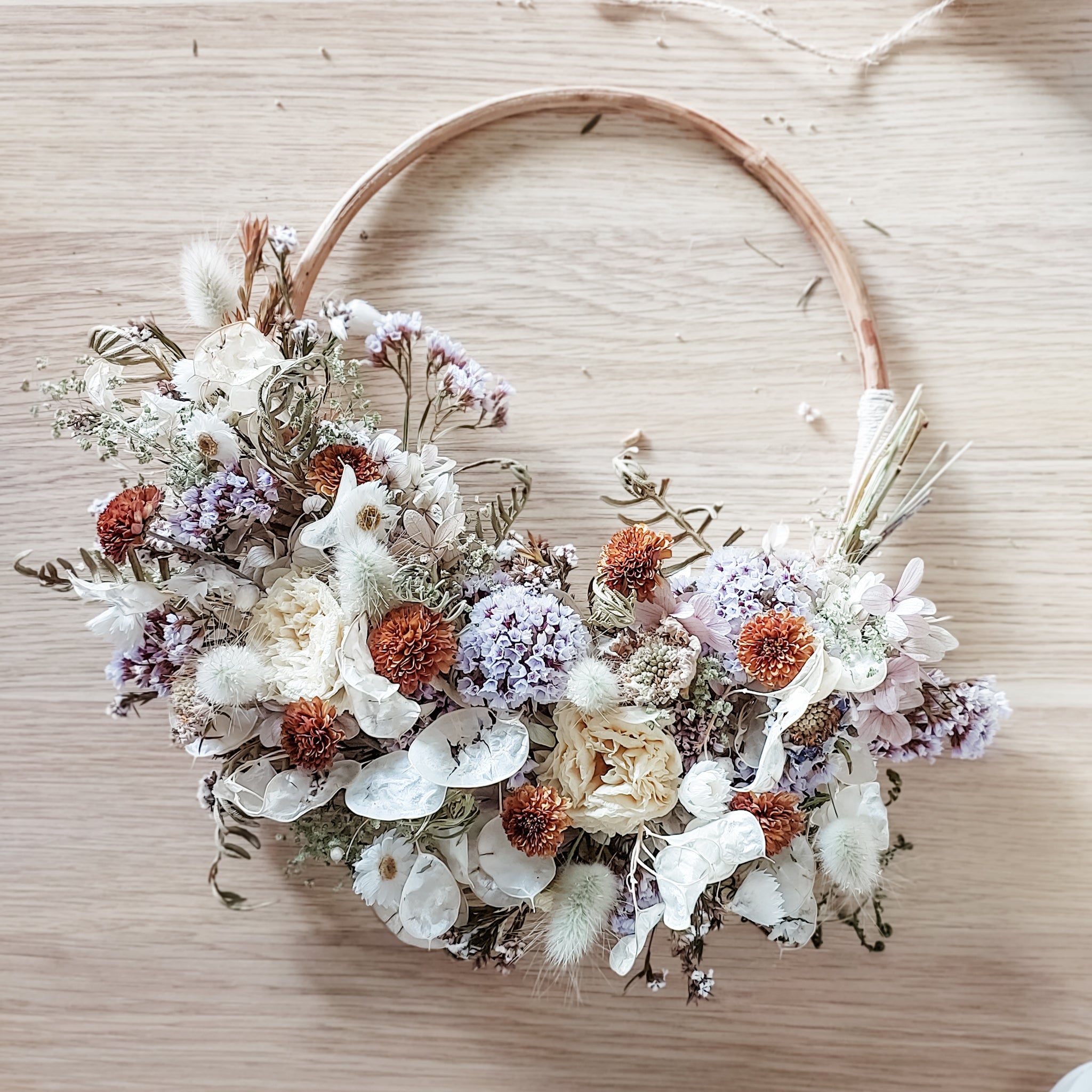 Dried flower wreath in lilac tones on a rattan hoop base