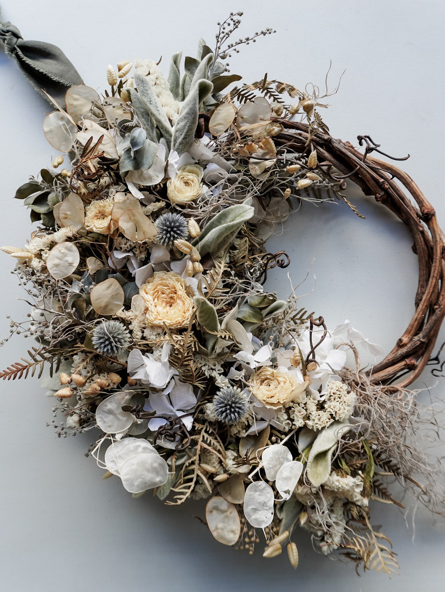 Dried flower wreath in natural tones on a grapevine base – birds eye view.