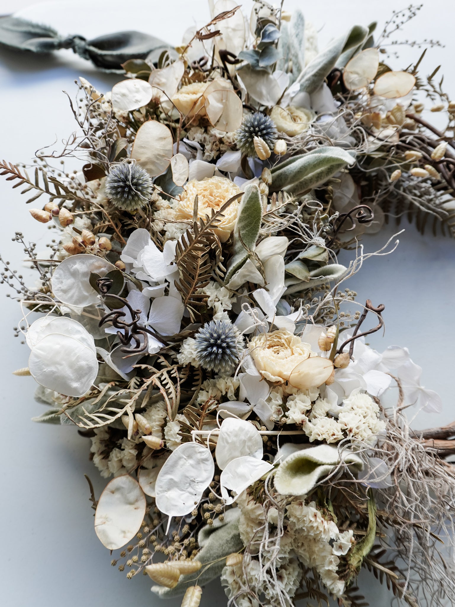 Dried flower wreath in natural tones on a grapevine base – extra close view.