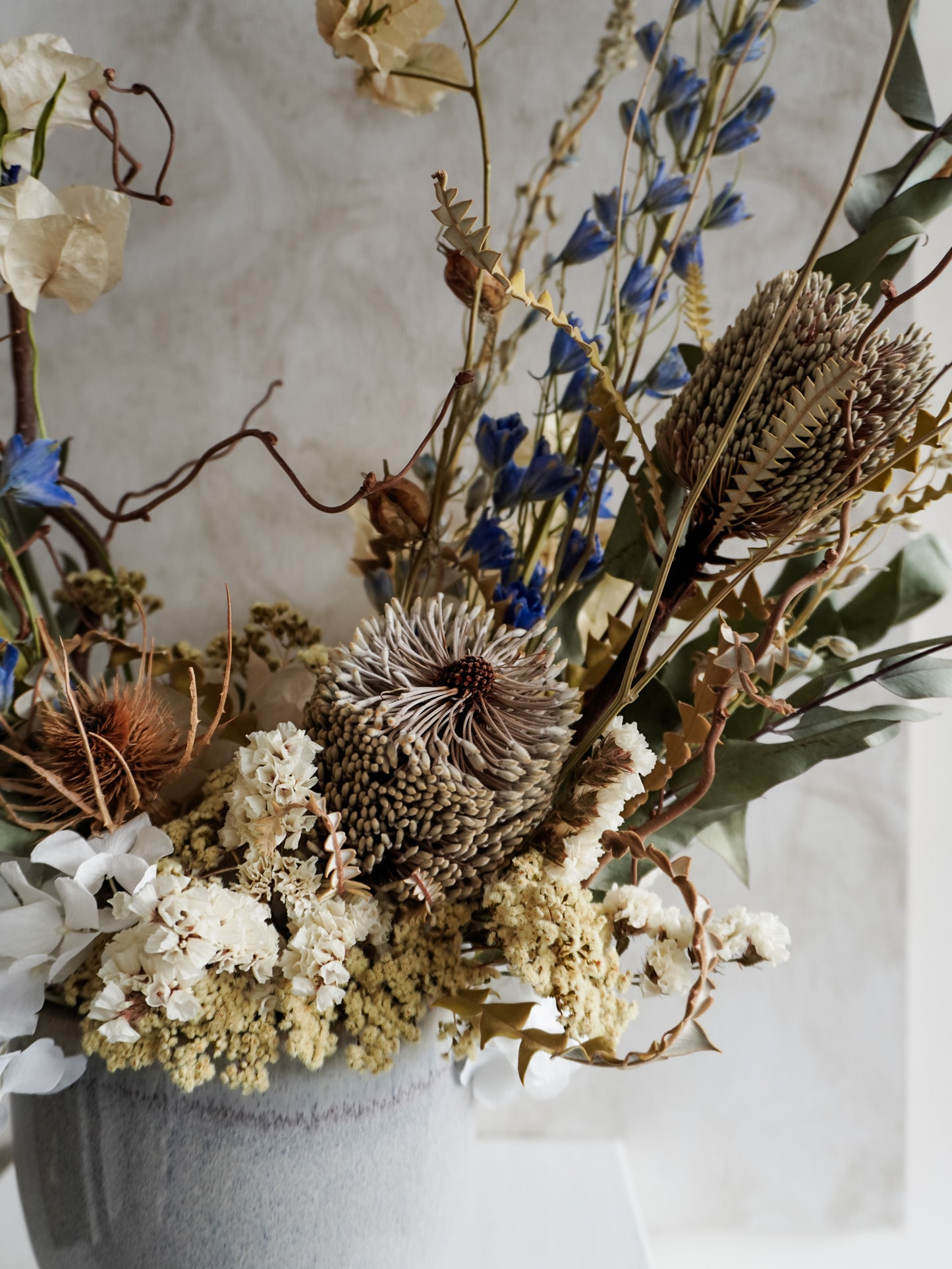 Close up view of dried flower arrangement highlighting focal flower of Banksia speciosa.