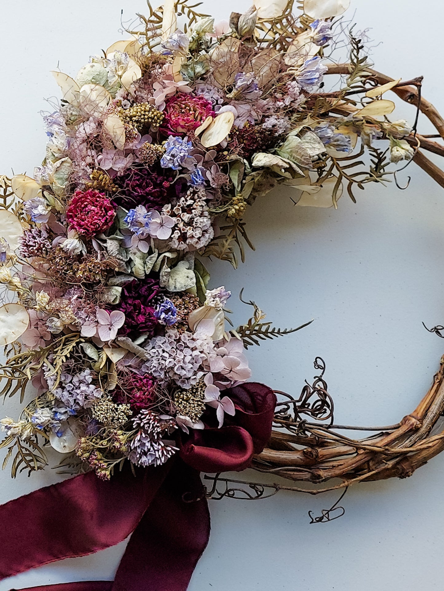 Completed handmade wreath design featuring blue violet dried florals.