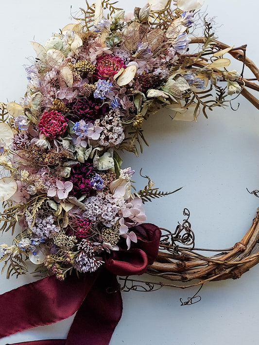 Completed handmade wreath design featuring blue violet dried florals.