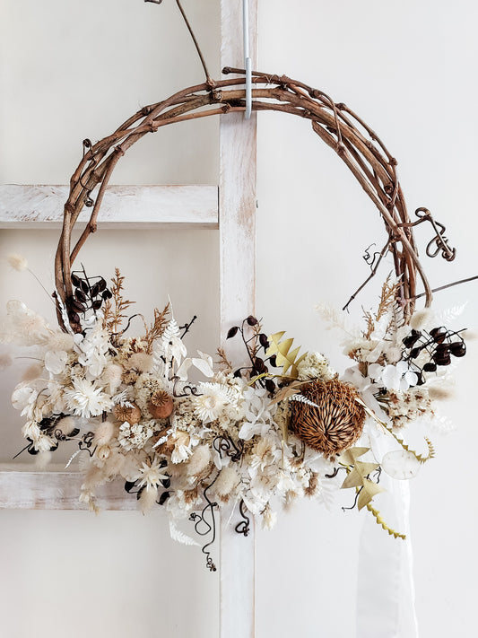 Dried flower wreath in a boho style in neutral whites on a grapevine base – close full view.
