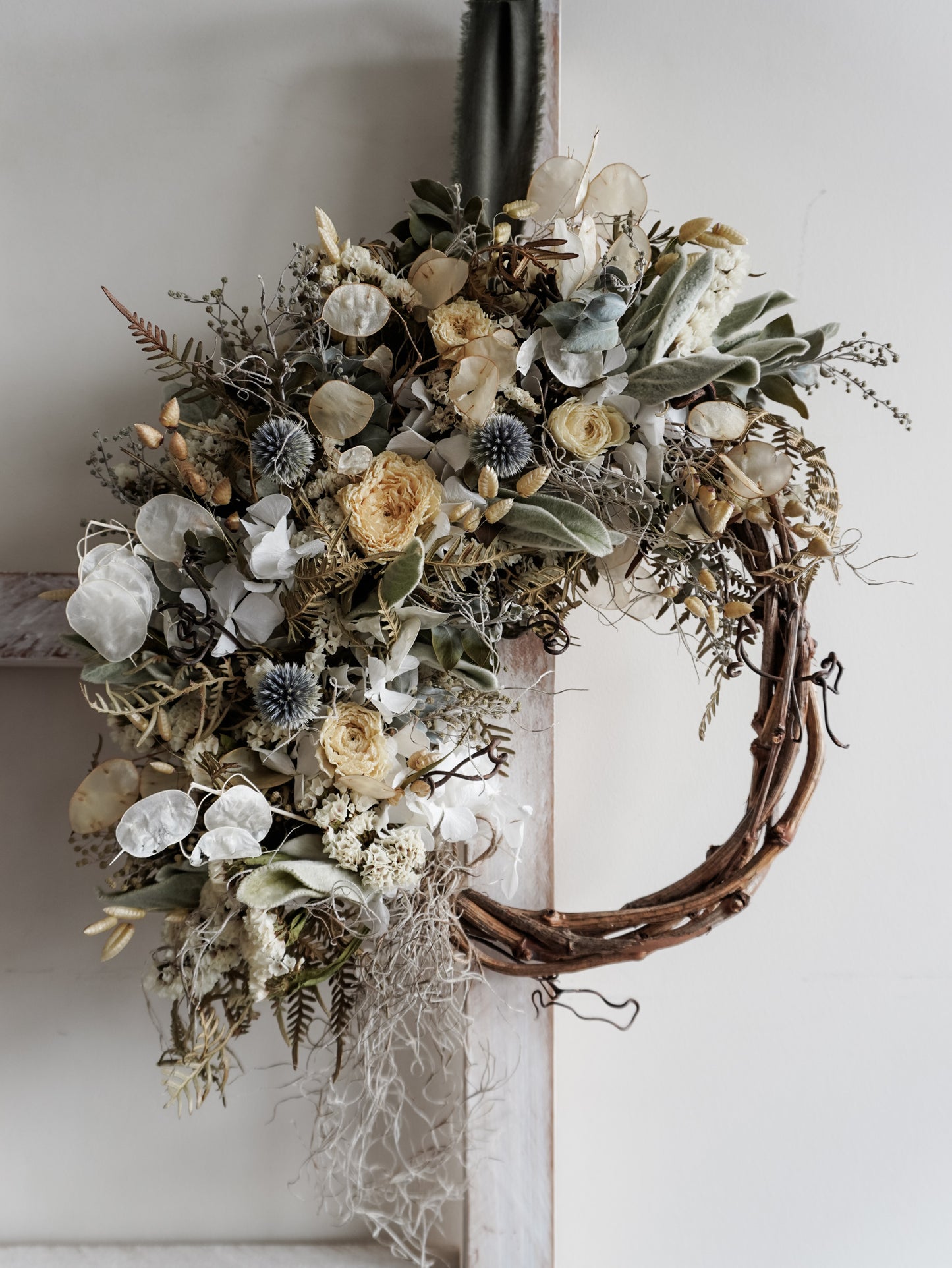 Dried flower wreath in natural tones on a grapevine base – close full view.