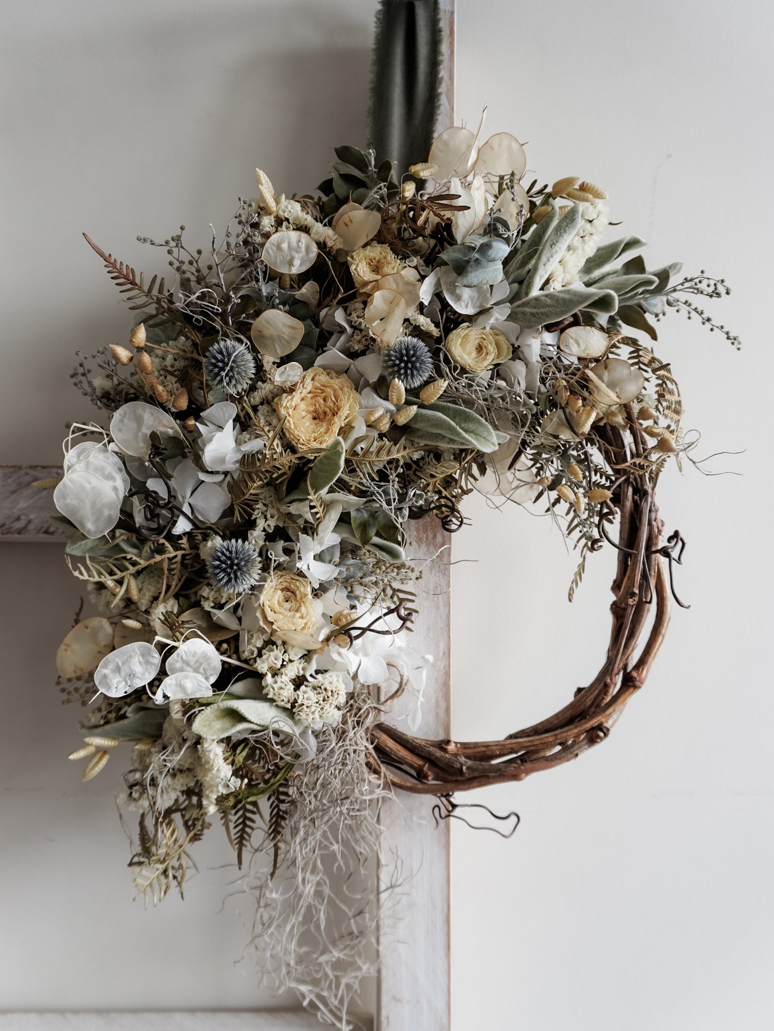 Dried flower wreath in natural tones on a grapevine base – close full view.