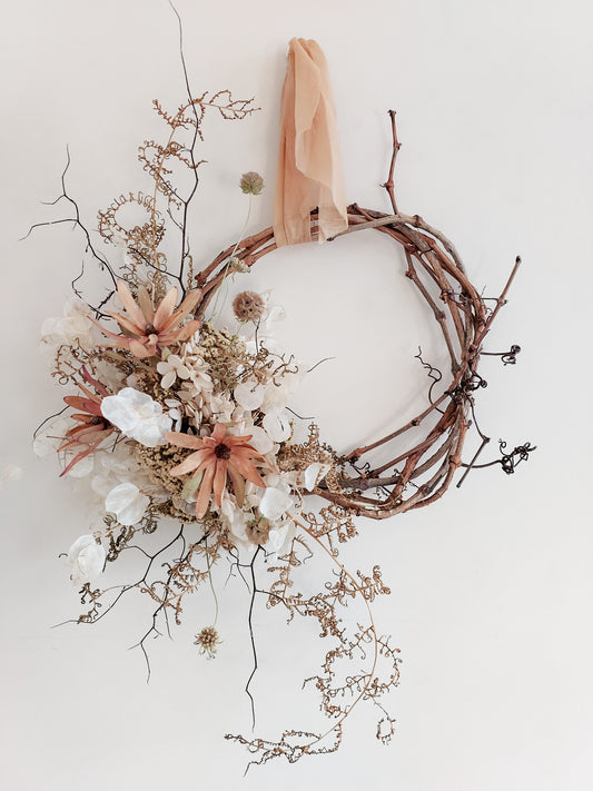 Dried flower wreath in a wild, natural style in neutral tones on a grapevine base – close full view.