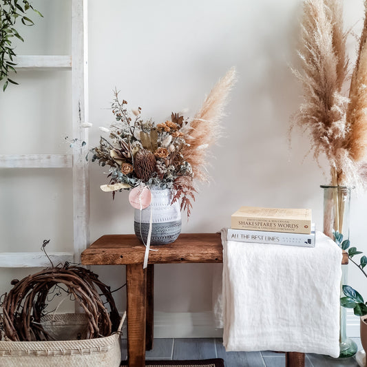 Dried flower vase arrangement in neutral tones set amongst elegant interior styling.