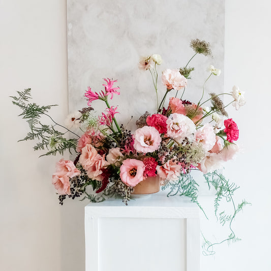 Table arrangement of luxurious pink toned flowers.