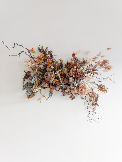 Dried flower wall hanging in pastel tones – distant full view.