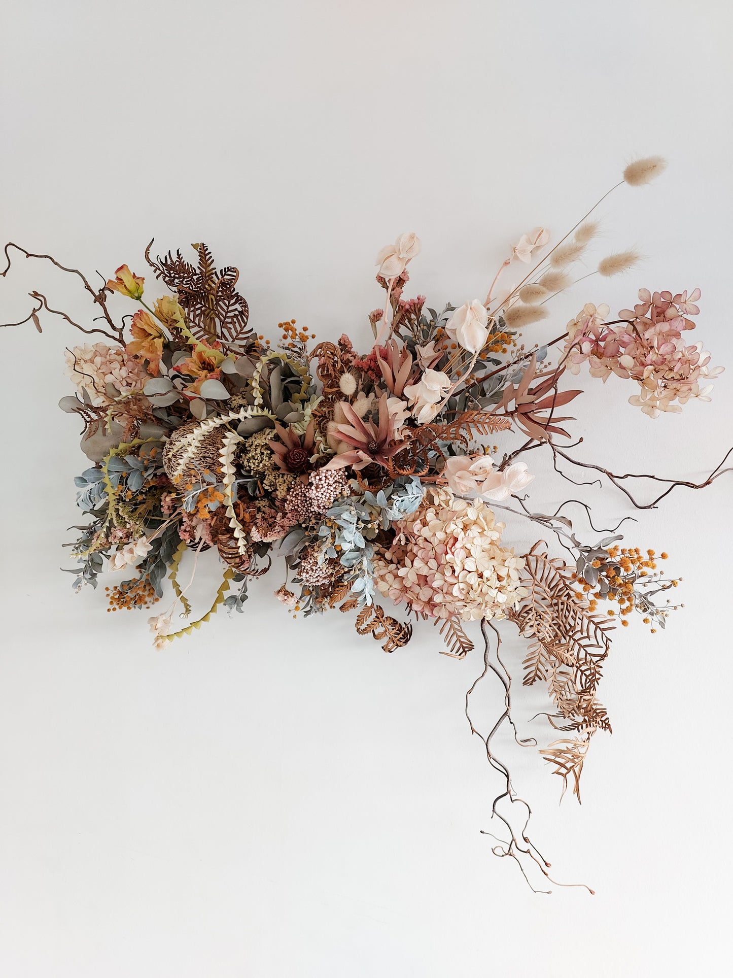 Dried flower wall hanging in pastel tones – right angle full view.