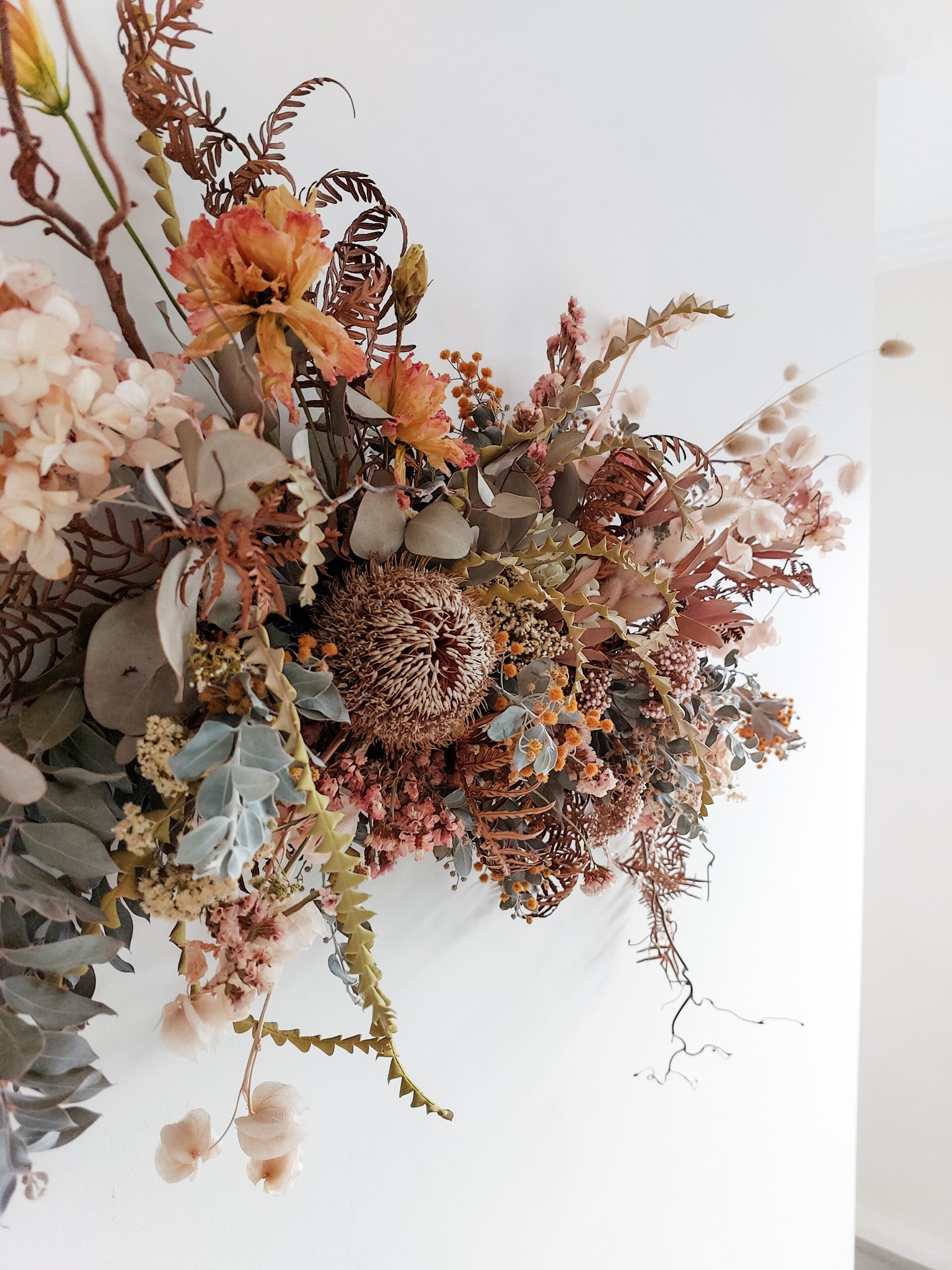 Dried flower wall hanging in pastel tones – left angle close view.