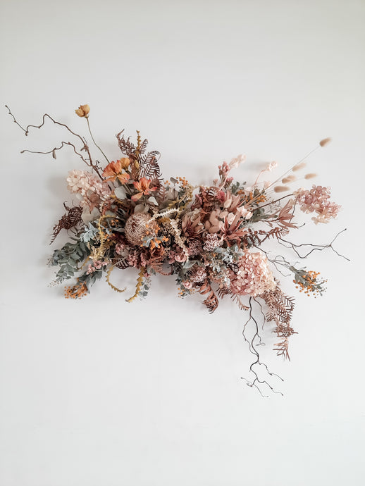 Dried flower wall hanging in pastel tones – distant full view.