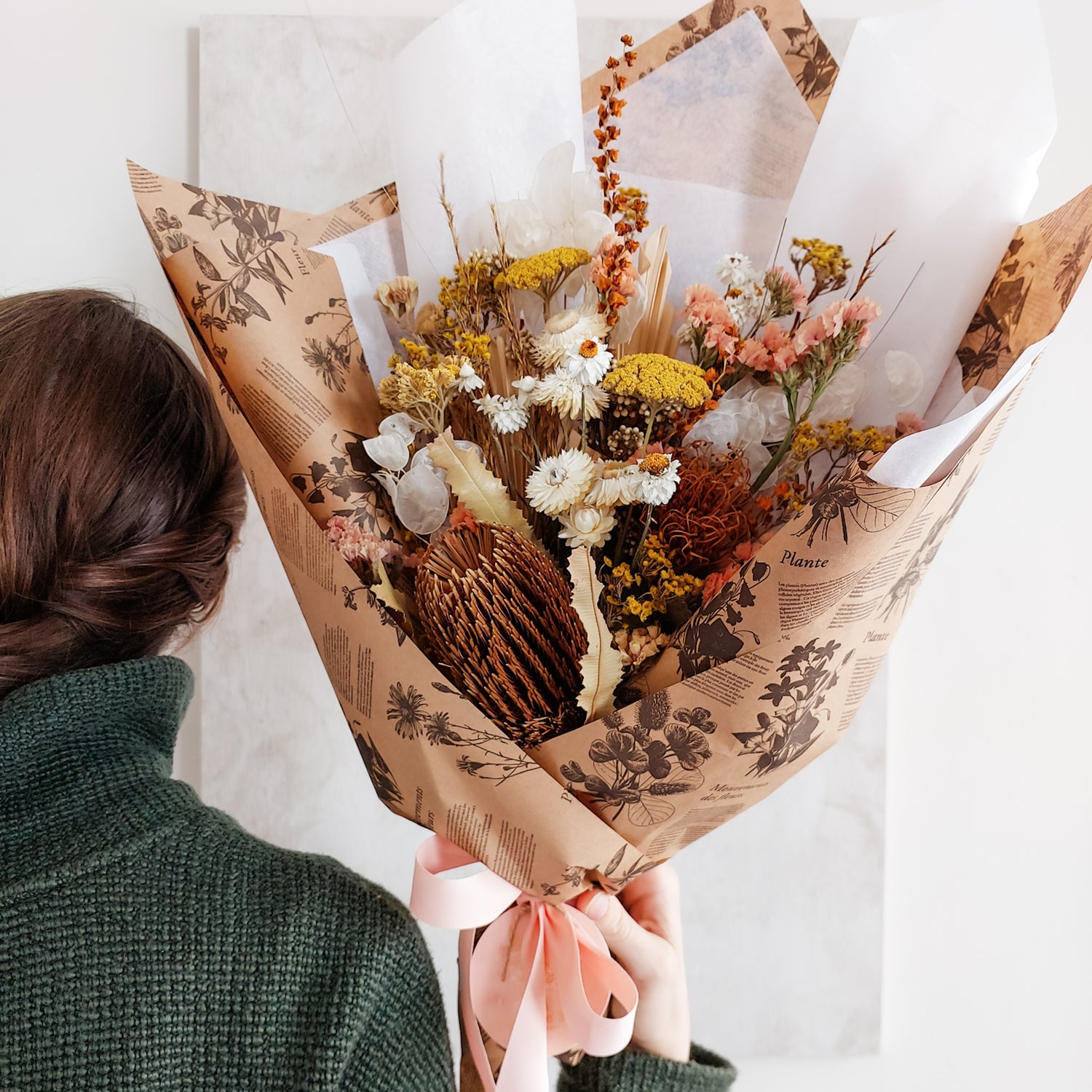 Dried flower bouquet in warm golden tones wrapped ready for gifting