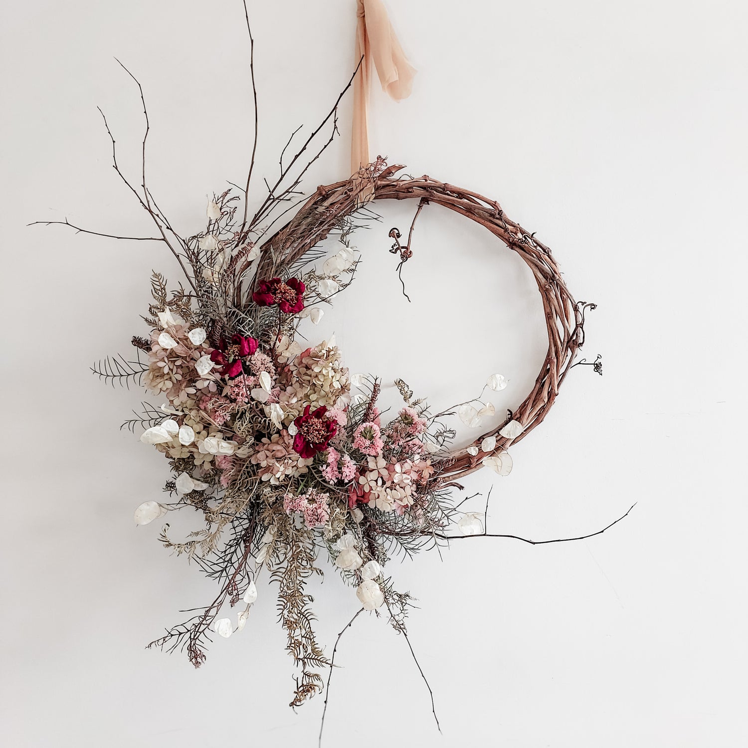 Dried flower wreath in a wild and whimsical style on a grapevine base.