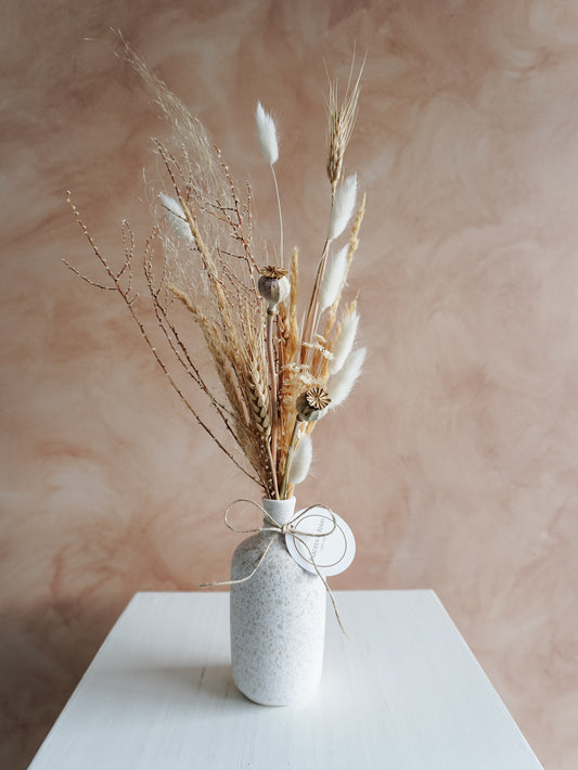 Dried flower arrangement in ceramic bud vase with white and neutral florals – close view.