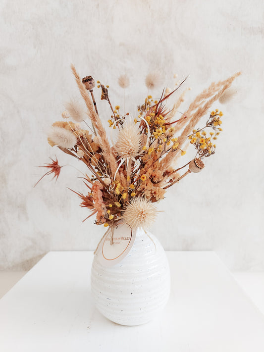 Dried flower arrangement in bud vase with orange florals – close full view.