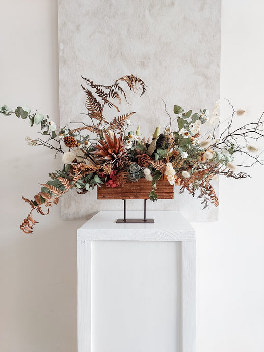 Dried flower centrepiece in rustic vase featuring natural textural florals – front view 1.