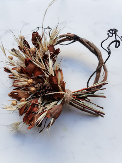 Dried flower mini wreath decoration in earthy tones on a grapevine base – close full view.