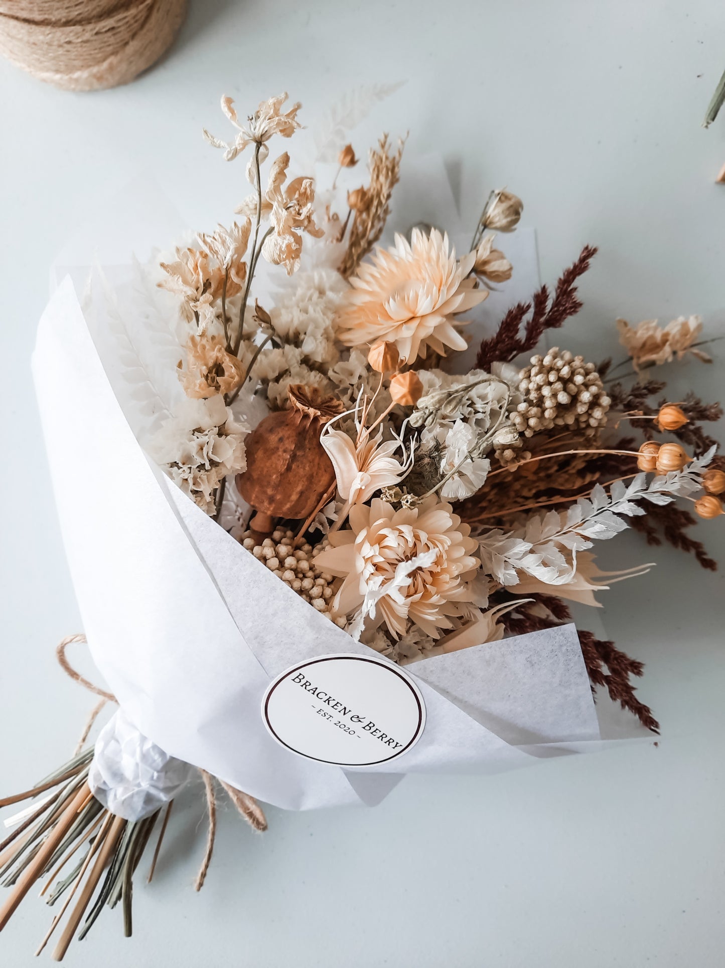 Dried flower posy wrapped in tissue paper - earthy neutral tones.
