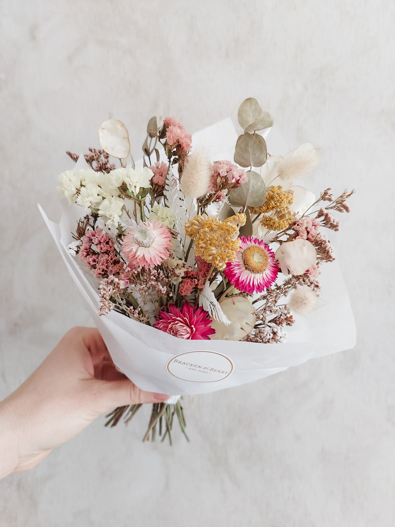 Dried flower posy wrapped in tissue paper - soft feminine tones.