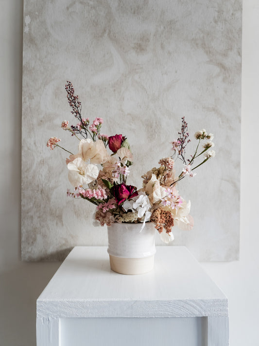 Dried flower arrangement in ceramic vessel with pastel florals and deep pink roses – full view.