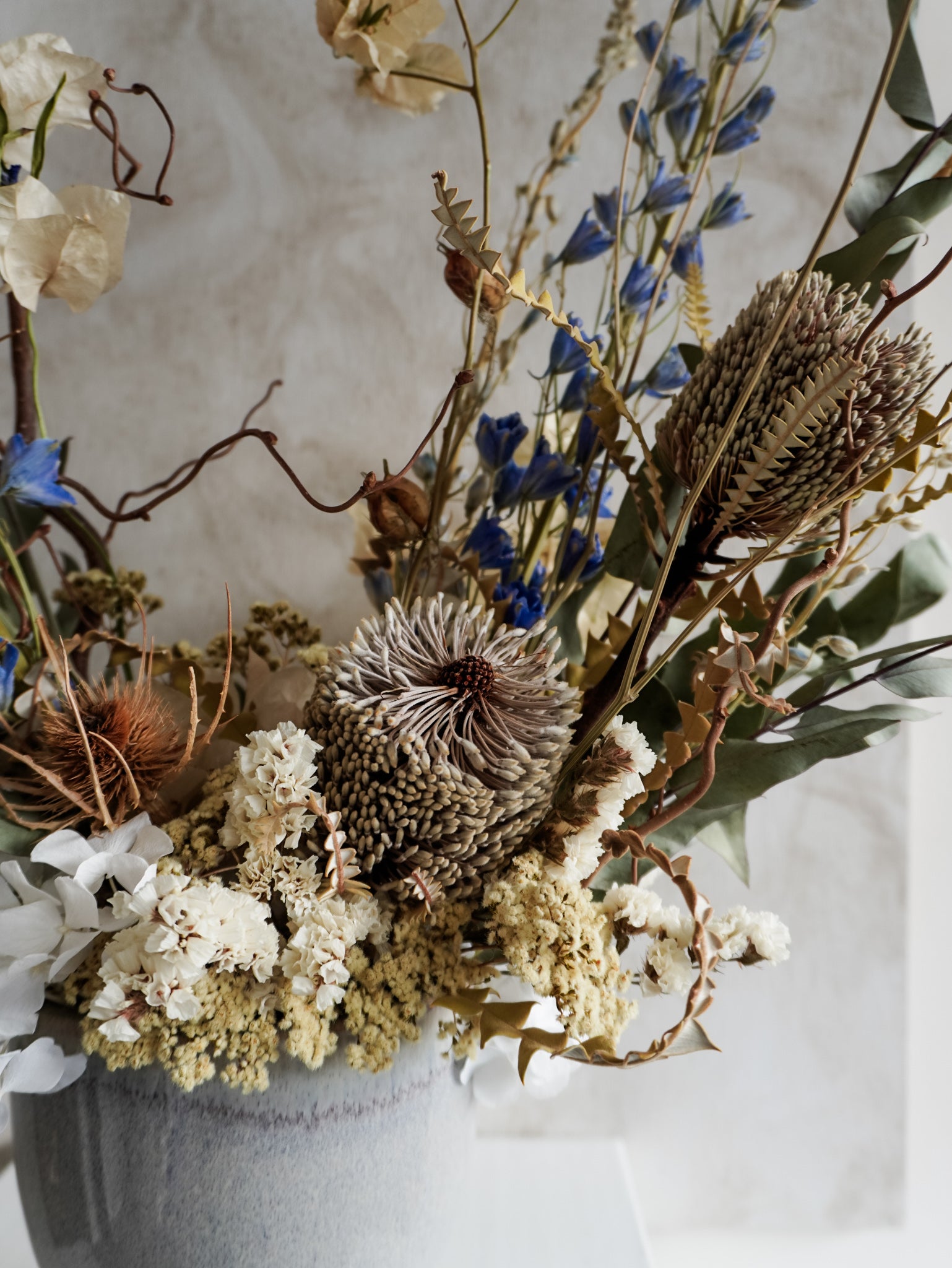 Close up view of dried flower arrangement highlighting focal flower of Banksia speciosa.