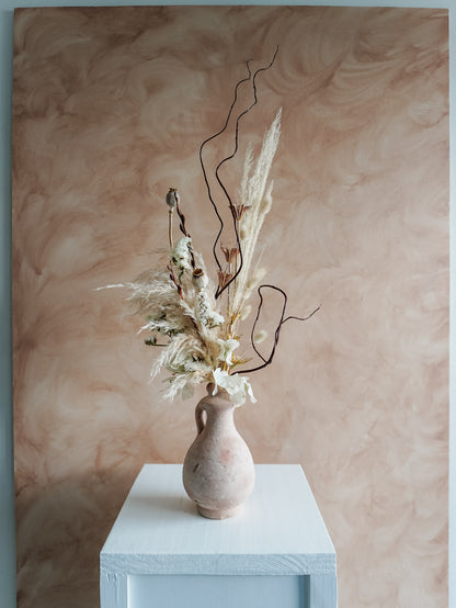 Dried flower arrangement in a ceramic vessel with neutral textural florals – distant view.