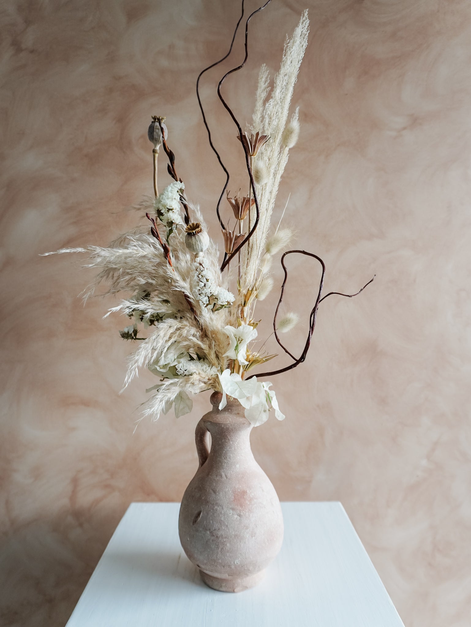 Dried flower arrangement in ceramic vessel with neutral textural florals – close view.