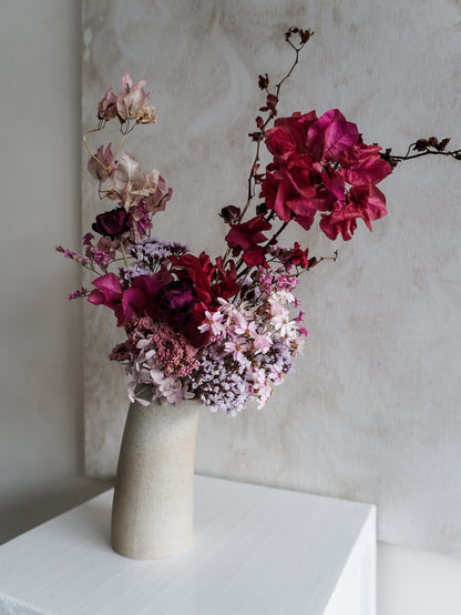 Dried flower arrangement in ceramic vase with deep pink florals – right side view.