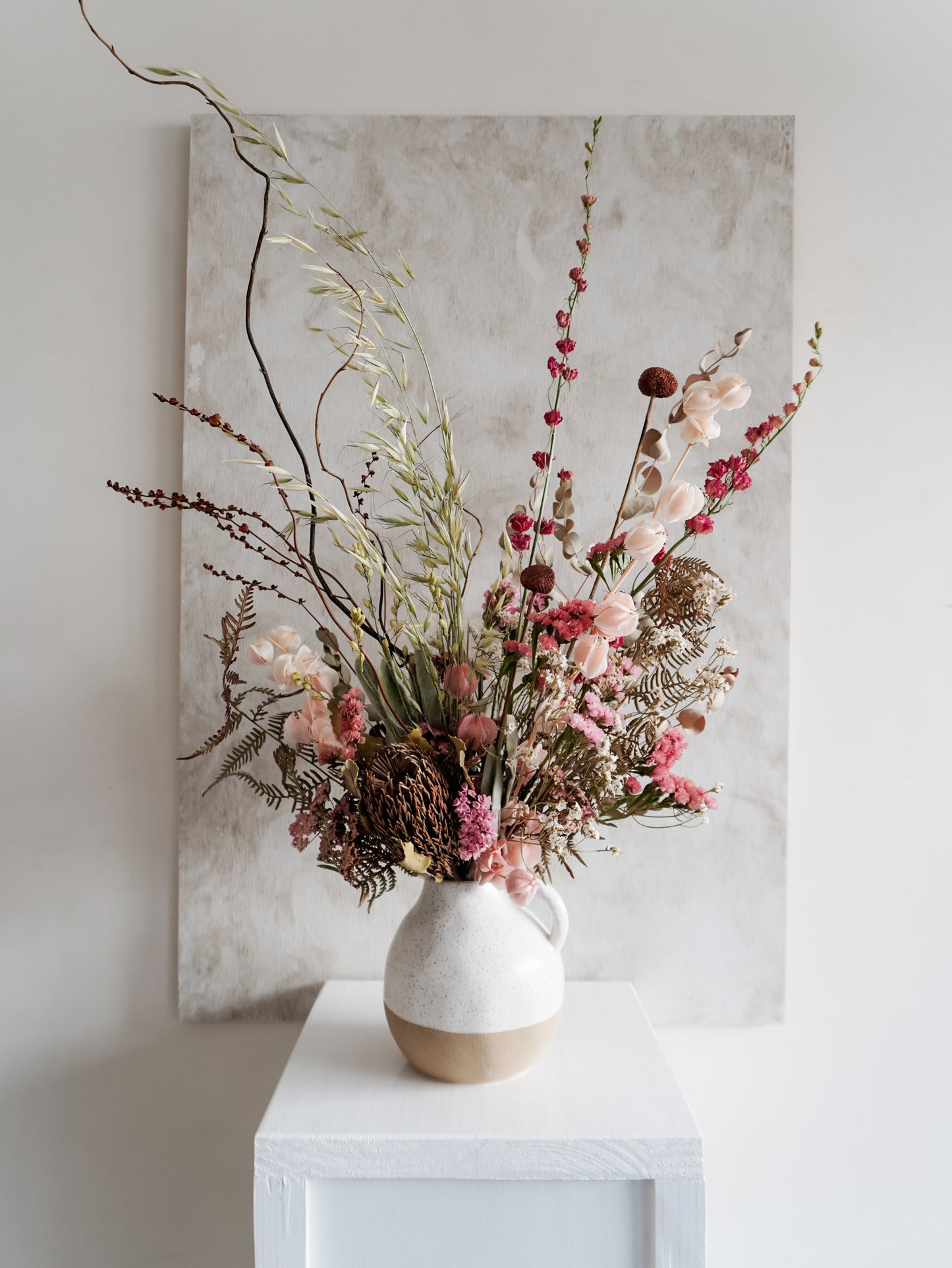 Dried flower arrangement in ceramic jug vase with soft pink florals – full view.