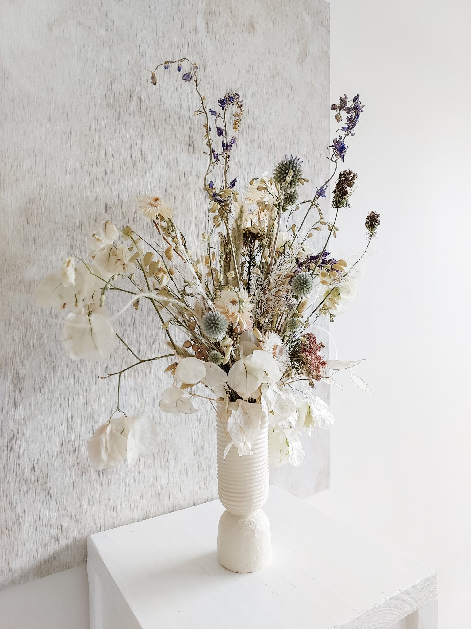 Dried flower arrangement in ceramic vase with whimsical florals – left angle view.