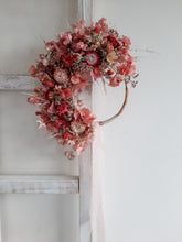 Load image into Gallery viewer, Dried flower wreath in berry tones on a rattan hoop base – distant full view.

