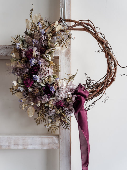 Dried flower wreath in soft blue violet tones on a grapevine base - Mystique Close View.