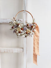 Load image into Gallery viewer, Dried flower wreath in lilac tones on a rattan hoop base – distant full view.
