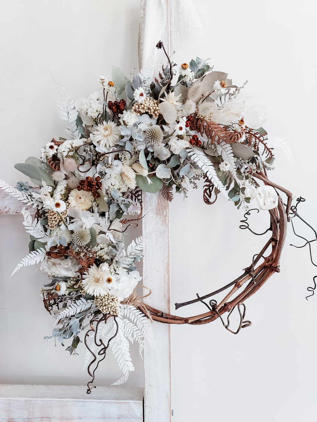 Dried flower wreath in natural tones on a grapevine base – close full view.