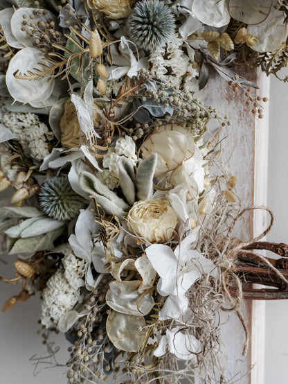 Close-up of dried florals and leaves on a decorative wreath.