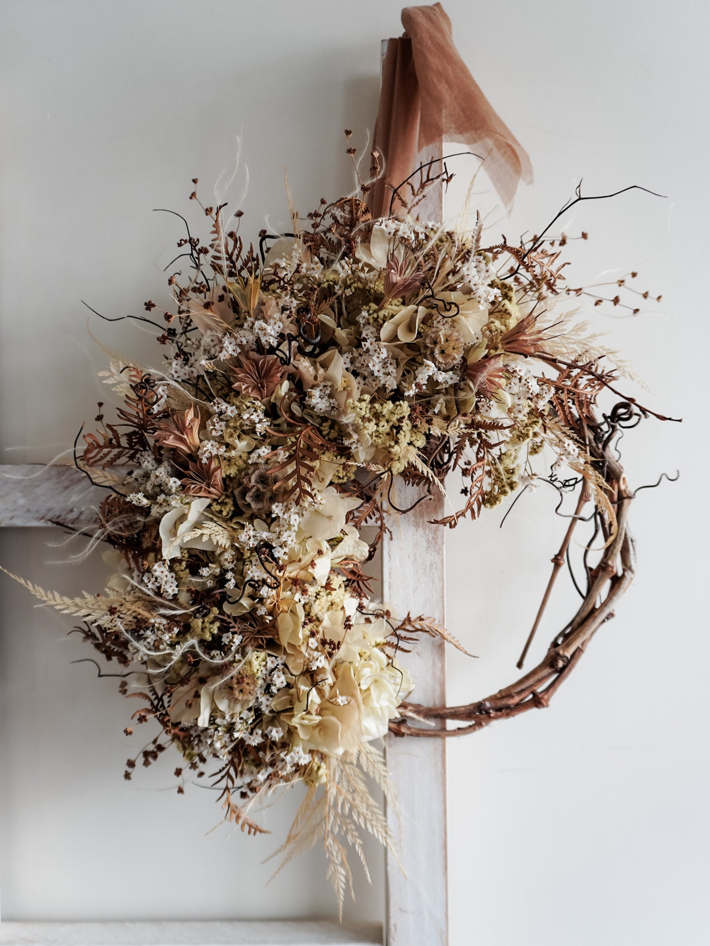 Dried flower wreath in neutral tones boho style on a grapevine base – close full view.